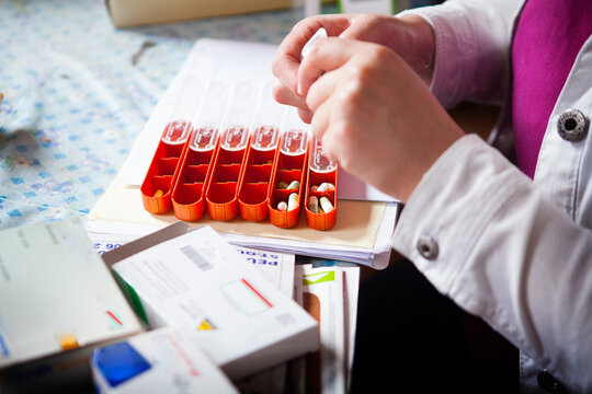 Nurse preparing the pillbox for her patient.