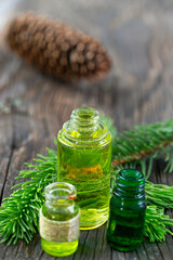 Close up of bottles of pine essential oil lying on a wooden board.