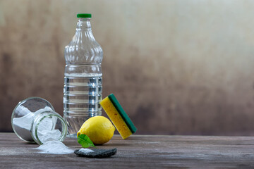 Household cleaning with baking soda lemon a sponge and a bottle.