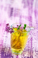Close-up of a sprig of oregano on top of a glass cup.