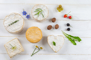 Normandy cheese platter placed on white board in top view.