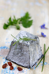 Close up of a single ashy goat cheese in top view.