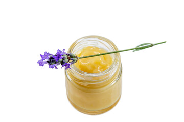 Close up of a jar of royal jelly covered by a sprig of lavender.