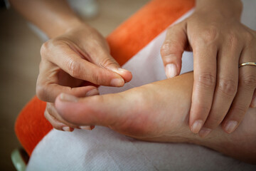 Fototapeta premium Naturopath putting acupuncture needles on a patient's foot.
