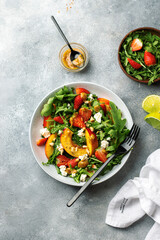 salad bowl with arugula, strawberry, cottage cheese, nectarine and peanut paste. healthy eating concept