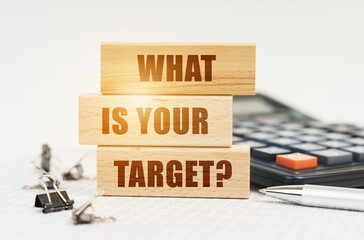 On the reports is a pen, calculator, clips and wooden boards with the inscription - WHAT IS YOUR...