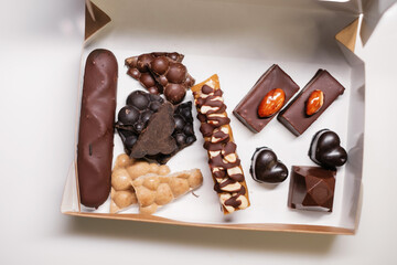 Various chocolates in cardboard box. Close-up.