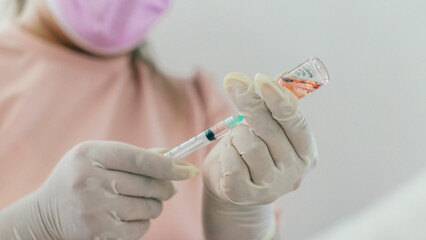 Doctor filling a syringe for cosmetic surgery. 