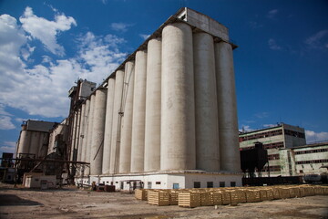 Kyzylorda Province, Kazakhstan - April 30, 2019. Outdated Soviet concrete grain elevator. Blue sky, clouds.
