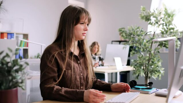 Young businesswoman thoughtfully pondering on camera and shrugs. Attractive young woman in the office. High quality 4k footage