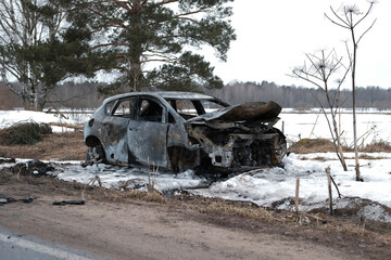 Burnt car with small flames inside of the engine. Burnt new car. malfunction that led to the death...