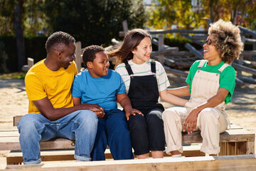 Cheerful multiracial happy family outdoors laughing, smiling multicultural diverse young people group having fun embracing celebrating reunion