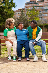 Portrait of african american family. Happy parents posing with son on a park bench.