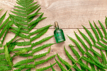 Natural cosmetics perfume essential oil serum in green glass bottle with dropper, wooden background...