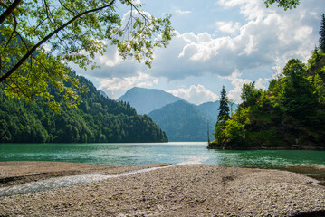 Lake shores among mountains covered with green forest