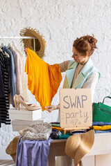 Young women at swap home party - clothes, shoes, bags, jewellery exchange between friends, taking...