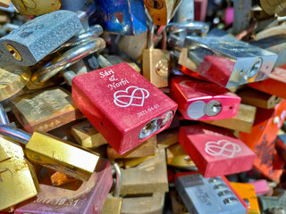 Detail of bunch of love locks fixed on each other. They are of various colors.