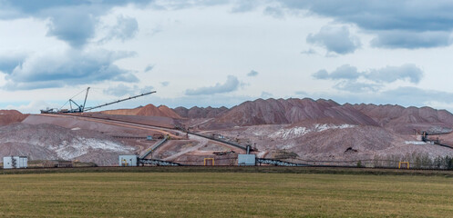 Giant spreader or absetzer machinery. A large dumper on a landfill with potash ore. Extracting...