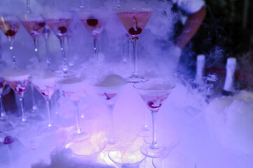 Glasses of champagne with dry ice. Champagne slide. Pyramid or fountain made of champagne glasses