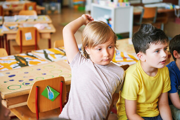 Two concentrated 4-5 year old boys in classroom, preschool children