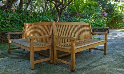 Fototapeta na wymiar Oak Benches in a Shaded Garden.