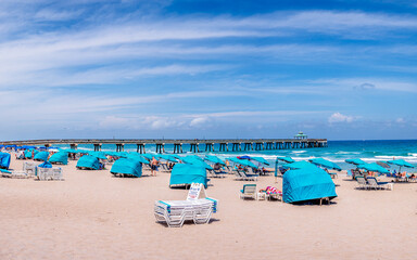 Fototapeta na wymiar Deerfield Beach, Florida with tourist people and ocean. Pier with clouds in sky. 