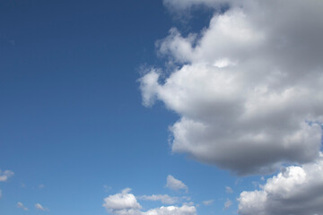 Naklejka na ściany i meble A blue sky with white clouds, as a background.