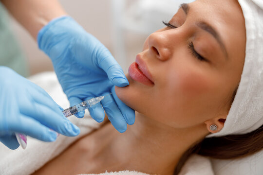 Closeup of young woman receiving hyaluronic acid injection in beauty salon. Cosmetology