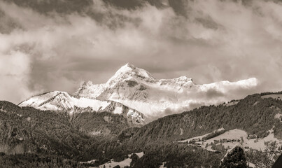 Fototapeta na wymiar illustration d'un paysage de montagne sous la neige sous un ciel nuageux en noir et blanc