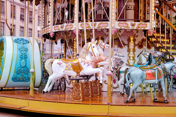 children's carousel is decorated with multicolor lights, decorations, a fairground ride with horses...