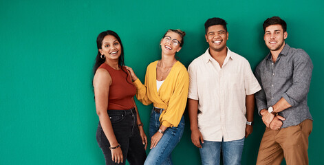 Optimism is a strategy for making a better future. Portrait of a group of young designers standing together against a green background.