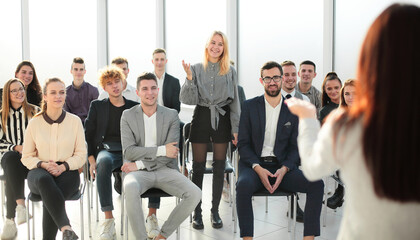 business woman answering questions from employees during a briefing