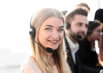 young call center operators on the background of her colleagues