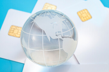 Buy now pay later, BNPL consumerism and global credit concept with transparent glass globe on credit cards isolated on blue background