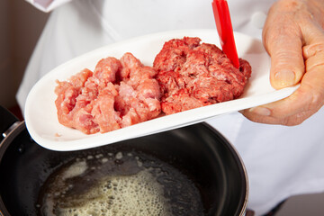 Preparation of ground beef with the traditional Colombian hogao or criollo sauce (salsa criolla) made of onion, tomato, peppers and cilantro