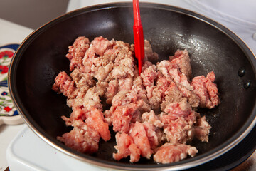 Preparation of ground beef with the traditional Colombian hogao or criollo sauce (salsa criolla) made of onion, tomato, peppers and cilantro