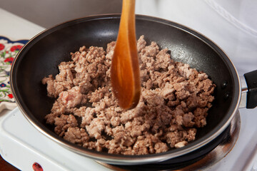 Preparation of ground beef with the traditional Colombian hogao or criollo sauce (salsa criolla) made of onion, tomato, peppers and cilantro