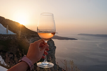 Hand holding a glass of a rose wine with a view