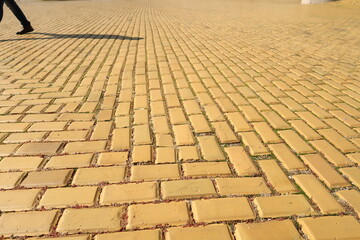 Yellow cobblestone, brick road in Sofia, shadow of pedestrian in the background