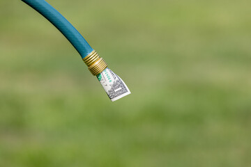 Garden hose and cash money. Water bill, conservation and usage concept
