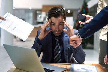 The demands of work can be stressful. Shot of a stressed out businessman sitting at his office desk...