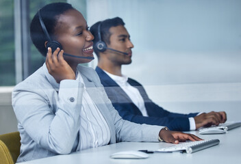 Hello. What can I do for you today. Cropped shot of two young call center agents working at their desks in the office.