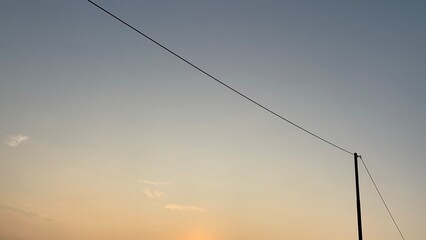 Electric power pole on morning sky background
