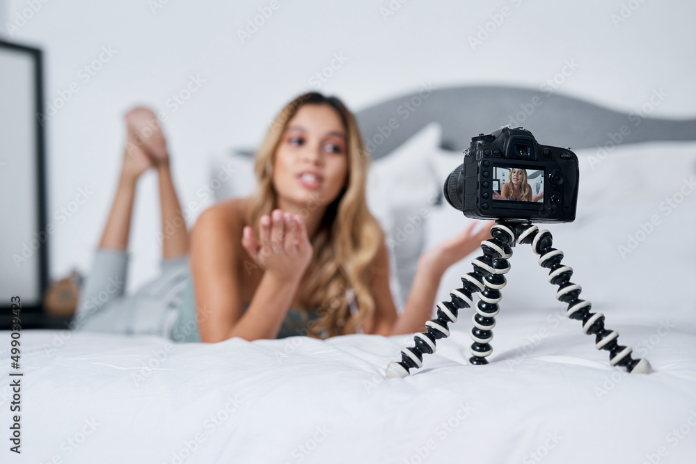 Poster today im sharing a little bit more about myself. shot of a young woman using a tripod while recordin