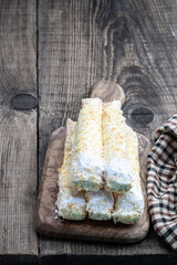 Flaky sweet rolls with cream on wooden table