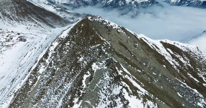 Snow mountain Aerial landscape peak of Mount Siguniang at Sichuan China  with mist floating under blue sky ,camera tilt up