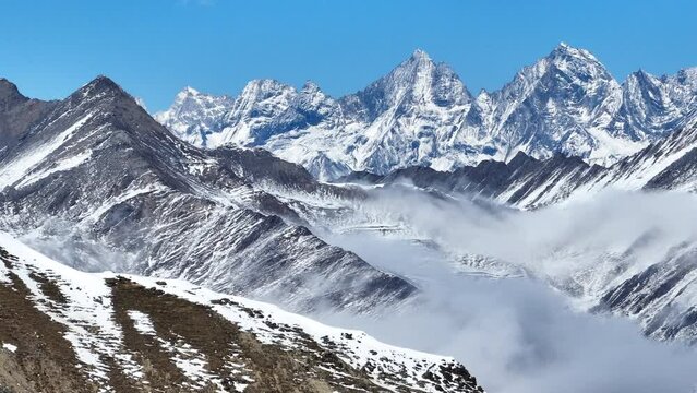 Aerial landscape of snow mountain peak of Mount Siguniang at Sichuan China snow mountain with mist floating under blue sky