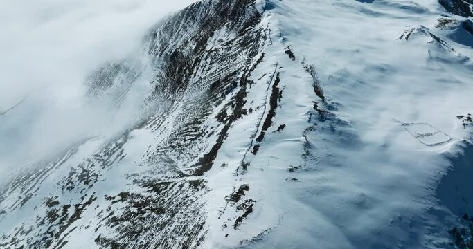 Snow mountain Aerial landscape peak of Mount Siguniang at Sichuan China  with mist floating under blue sky ,camera tilt up