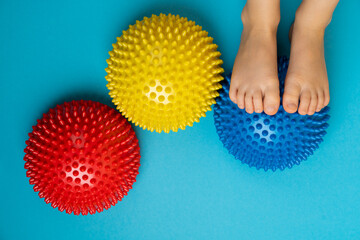children's feet with a colored balancer on a light blue background, treatment and prevention of...