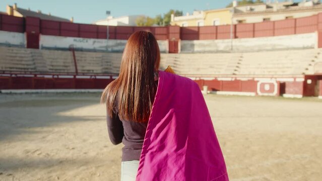 Backview Of A Young Female Bullfighter With Muleta Over Her Shoulder At The Bullring. Tracking Shot